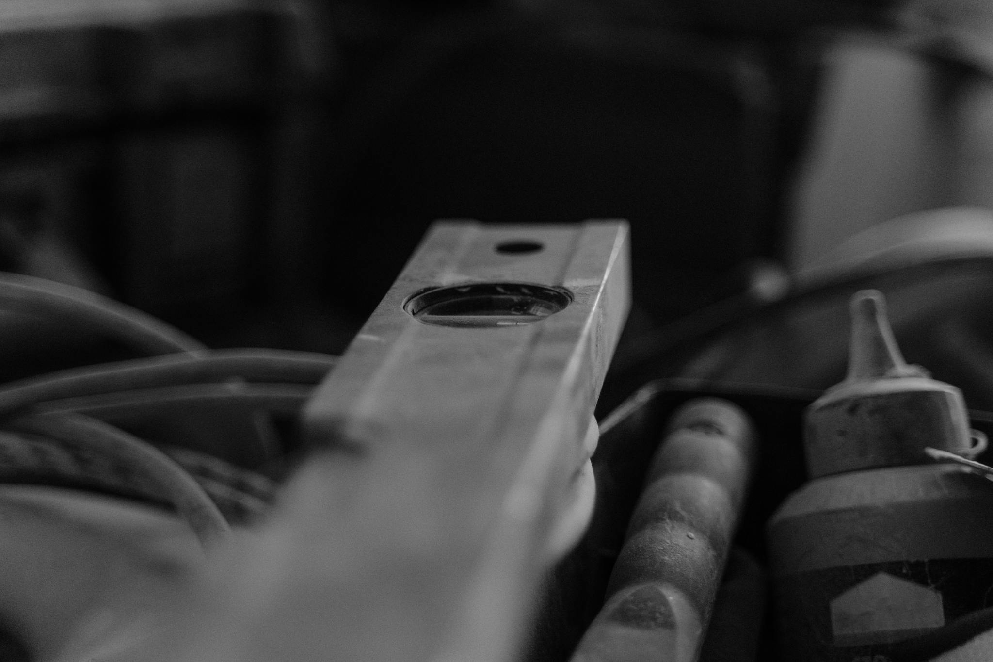 Black and white image of construction tools in a workshop, emphasizing a spirit level.